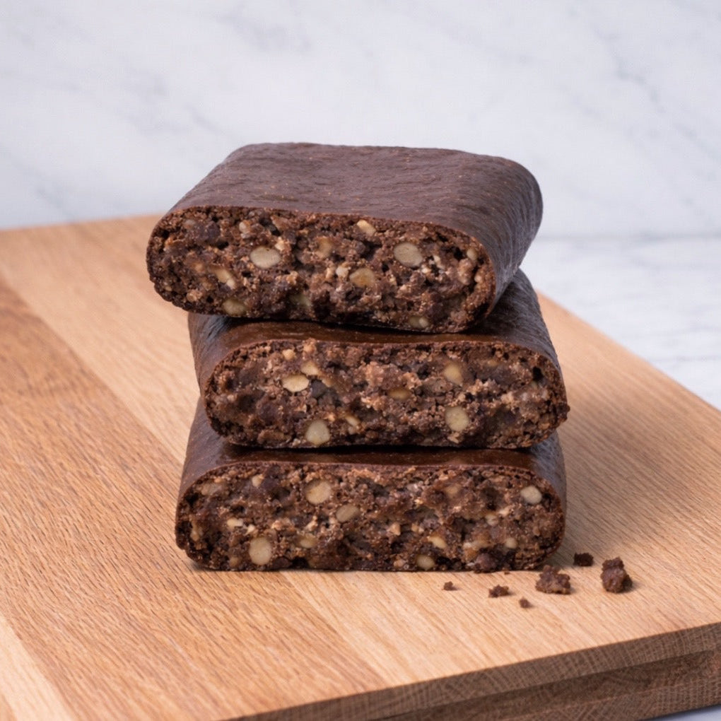 Front view of Chocolate Crunch bars stacked to show cross-section with crunchy nut and crisp pieces on a wooden board