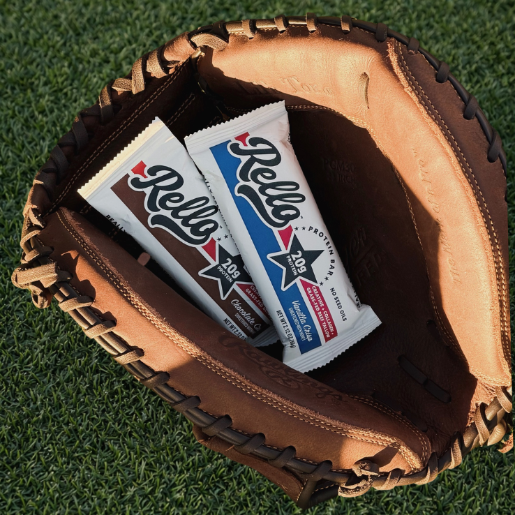 Two Rello Bars in a brown leather glove on a grass background