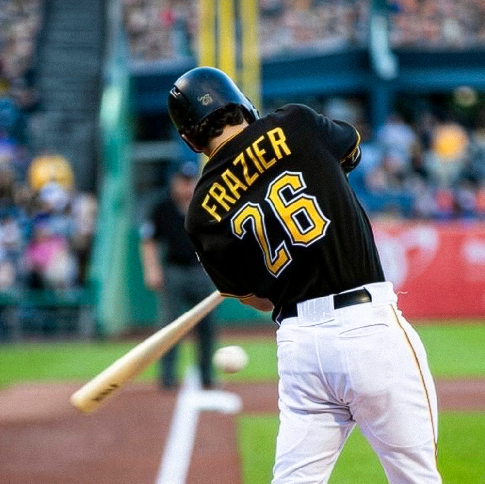 Baseball player swinging a bat during a game at a stadium, wearing a black jersey and white pants