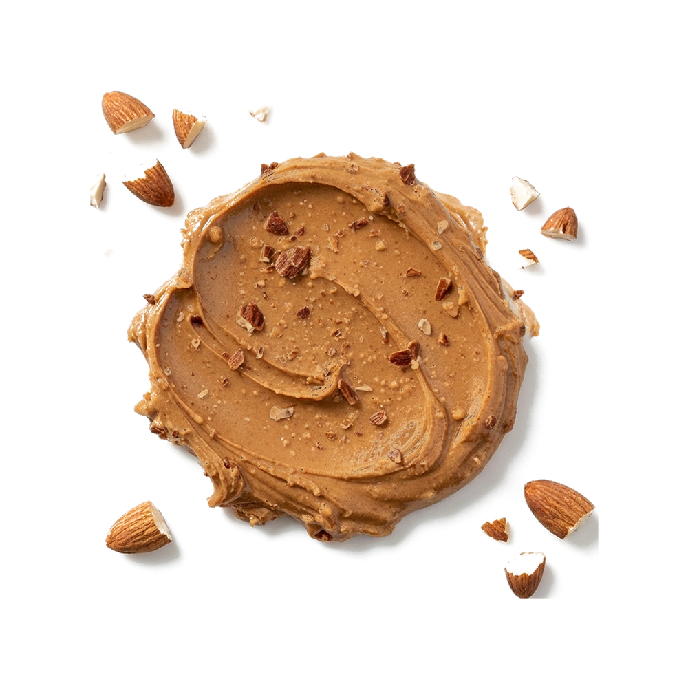 Top-down view of organic almond butter smear with chopped almonds on white background